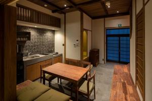 a kitchen with a wooden table and a dining room at Natsume an Machiya House in Kyoto