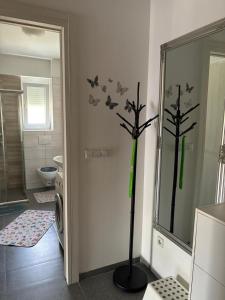 a bathroom with a tree with butterflies on the wall at Apartman VIVA in Bihać +16 photos