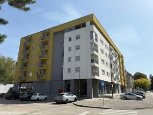 a building with cars parked in a parking lot at Apartman VIVA in Bihać