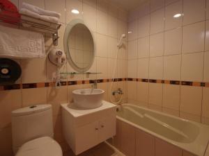 a bathroom with a toilet and a sink and a tub at Siaowan Homestay in Kenting