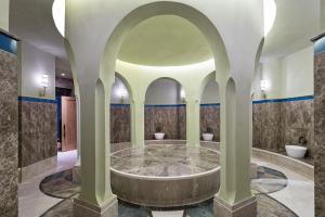 a bathroom with a large tub with two toilets in it at Titanic Luxury Collection Bodrum in Guvercinlik +39 photos