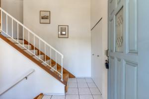 a staircase in a home with white walls and a blue door at 5BR Gem Walk to Microsoft and Near Redmond DT in Redmond