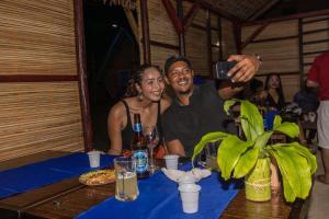 a man taking a picture of a woman at a table at le Repaire des Pirates in Sainte Marie