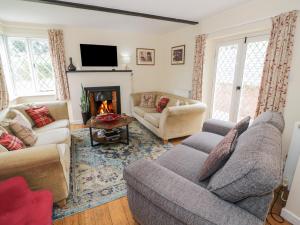 a living room with a couch and a fireplace at Hillside Cottage in Monmouth