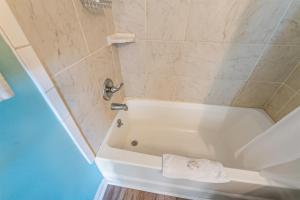 a white bath tub in a bathroom with a towel at Studio, North Myrtle - Dogs Allowed! in Myrtle Beach +9 photos