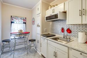 a kitchen with white cabinets and a sink and stools at Hike and Bike On-Site Burgaw Apt - 4 Mi to River in Burgaw