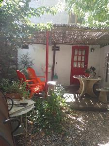eine Terrasse mit 2 Stühlen und einer roten Tür in der Unterkunft Alojamiento por día Merlo San Luis in Merlo