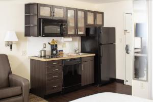 a kitchen with a black refrigerator and a microwave at Candlewood Suites Bellevue by IHG in Bellevue