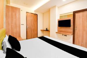 a bedroom with a large bed with a television at Hotel O Drishti Grand in Lucknow