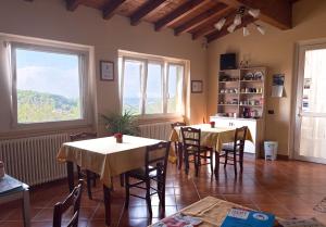 a room with two tables and a kitchen with windows at La Vecchia Cantina in Stradella