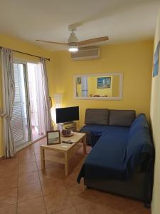 sala de estar con cama azul y TV en apartamento Isleta del Moro, Cabo de Gata, en La Isleta del Moro