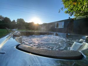 a hot tub in a backyard with the sun setting at The Forgotten Meadow in Ede