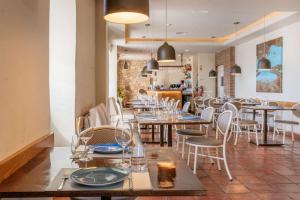 a restaurant with tables and chairs and a kitchen at Clube Albufeira Garden Village in Albufeira