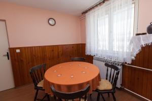 a dining room with a table and chairs and a clock at Apartment Anne in Crikvenica +10 photos