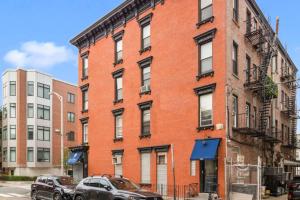 a red brick building with cars parked in front of it at Hoboken 15 Min Train to Manhattan Full Kitchen in Hoboken