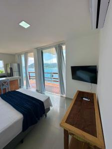 a bedroom with a bed and a view of the ocean at Pousada Vista Grega in Arraial do Cabo