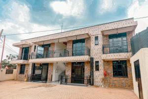 Un edificio de ladrillo con un balcón en la parte superior. en 2 bedroom apartment with a smart TV and Wi-Fi 15 mins from downtown Kigali, en Kigali