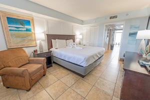 um quarto de hotel com uma cama e uma cadeira em Honeymoon Suite, Direct Oceanfront Suite, Pools! em Myrtle Beach mais 47 fotografias