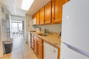 uma cozinha com armários de madeira e uma pia em Honeymoon Suite, Direct Oceanfront Suite, Pools! em Myrtle Beach