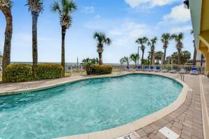 uma piscina com palmeiras e cadeiras em Honeymoon Suite, Direct Oceanfront Suite, Pools! em Myrtle Beach