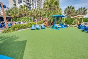 um playground com cadeiras azuis e um gazebo em Honeymoon Suite, Direct Oceanfront Suite, Pools! em Myrtle Beach