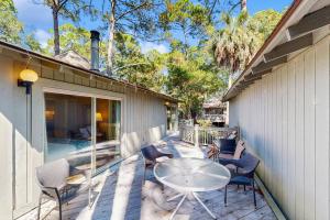 a patio with a table and chairs next to a building at 1038 Sparrow Pond in Kiawah Island