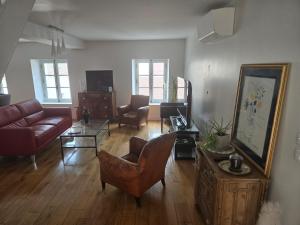 a living room with a couch and a table at Appartement de charme cœur de Thomery 3 chambres 1 à 9 pers in Thomery