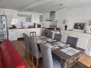 a kitchen with a dining table and chairs and a kitchen with white cabinets at Appartement de charme cœur de Thomery 3 chambres 1 à 9 pers in Thomery +24 photos