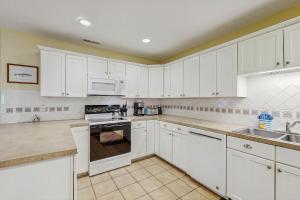 eine weiße Küche mit weißen Schränken und Geräten in der Unterkunft 1038 Sparrow Pond in Kiawah Island + 17 Fotos