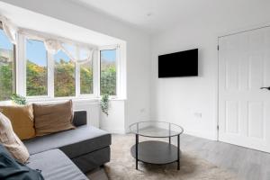a white living room with a couch and a table at 3Bed House-Free Parking in Alfreton