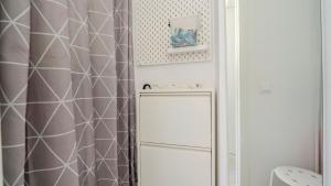 une salle de bain avec un rideau de douche et un réfrigérateur dans l'établissement Central Vilamoura Casa A, à Quarteira 14 autres photos