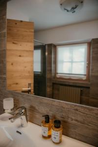 Stalina Alpine Chalet في ليفينو: حمام مزود بحوض ومِرآة