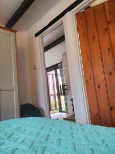 ein Schlafzimmer mit einem Bett und einem großen Fenster in der Unterkunft lovely Apple Cottage A peach in Bridport + 26 Fotos