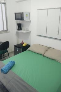 a bedroom with a bed and a microwave at Studio 1033 Niterói Centro in Niterói