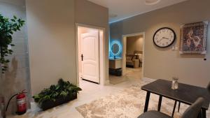 a living room with a clock on the wall at ضيافة البيان الفندقية in Jeddah