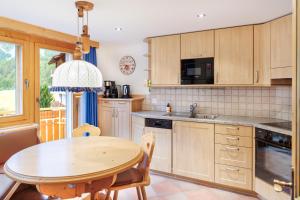a kitchen with a wooden table and a dining room at Dominic A in Saas-Fee
