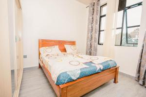 Un dormitorio con una cama en una habitación con ventana. en 2 bedroom apartment with a smart TV and Wi-Fi 15 mins from downtown Kigali, en Kigali