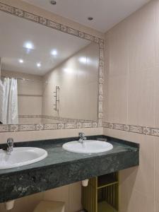a bathroom with two sinks and a large mirror at 212A Asueto apartamento en villaviciosa in Villaviciosa