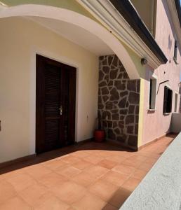 a hallway with a door and a stone wall at Casa Vacanze Sole in Monte Petrosu