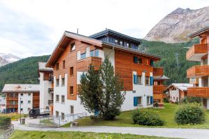 a group of buildings with mountains in the background at Dominic A in Saas-Fee