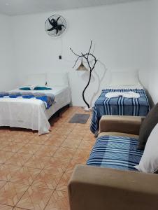 a room with two beds and a couch in it at Pousada Raizes de Lencóis in Lençóis