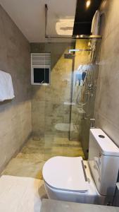 a bathroom with a toilet and a shower at The Releaf-Ambuluwawa in Gampola