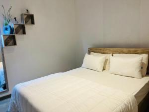 a bed with white sheets and pillows in a room at The Releaf-Ambuluwawa in Gampola +11 photos