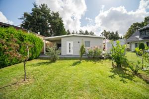 a garden with a small white house at Ferienhaus Kira in Rechlin
