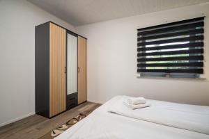 a bedroom with a bed with a mirror and a window at Ferienhaus Kira in Rechlin