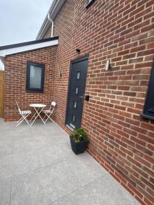 a brick wall with a door and a table and chairs at Siennas Modern 1 bed room apartment with ensuite in Kidlington +8 photos