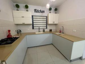 une cuisine avec des armoires blanches et un comptoir dans l'établissement Garden of Eden Estate, à Mashabbe Sade