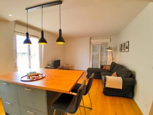 eine Küche und ein Wohnzimmer mit einem Holztisch in der Unterkunft T3 en face de la gare, Terrasse-Rooftop, Parking in Houilles