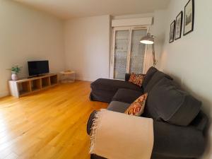 ein Wohnzimmer mit Sofa und Fernseher in der Unterkunft T3 en face de la gare, Terrasse-Rooftop, Parking in Houilles