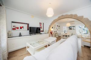 a living room with a white couch and a tv at La Casita in Pollença
